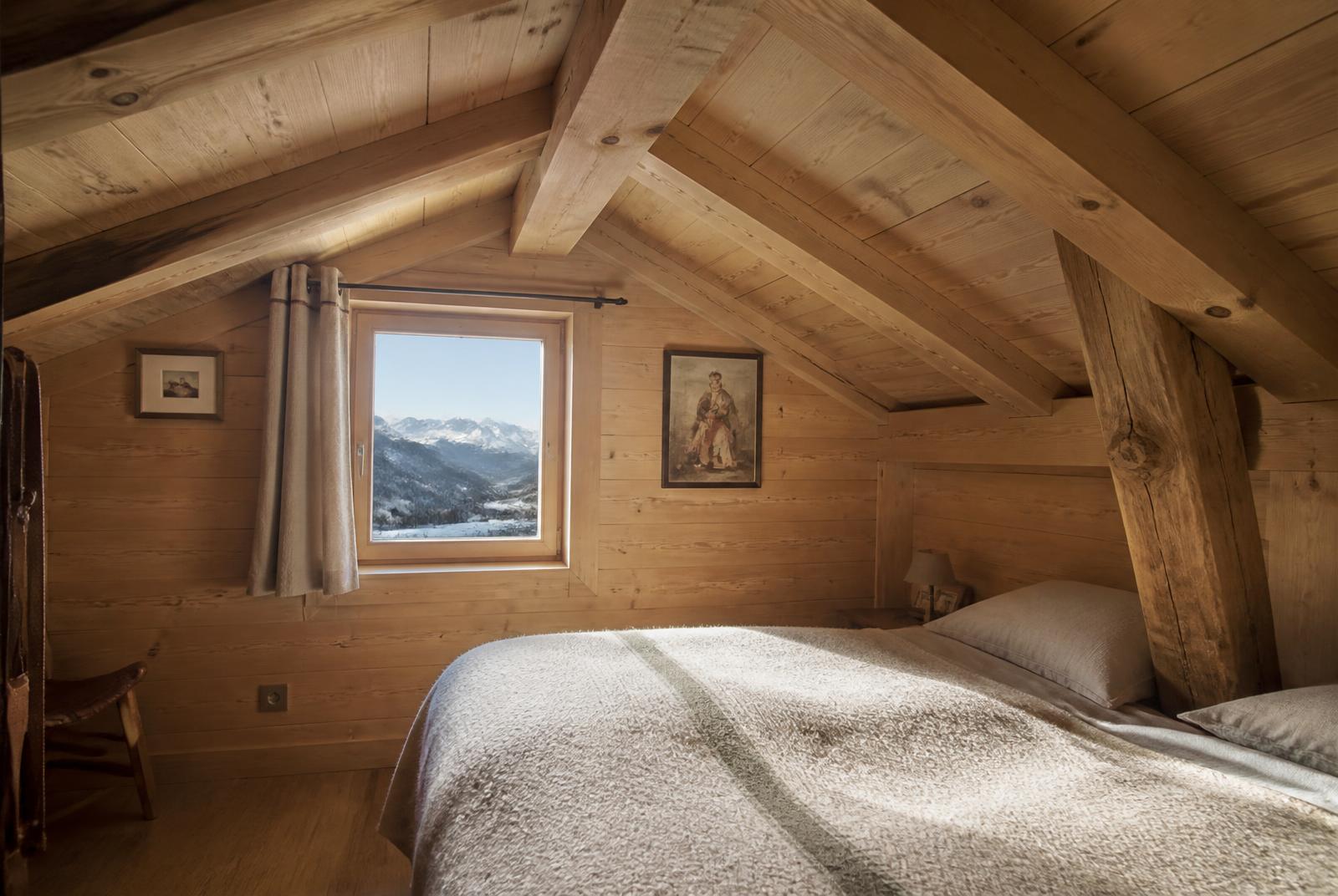 Chambre sous combles de chalet avec lambris sapin sur les murs et le plafond
